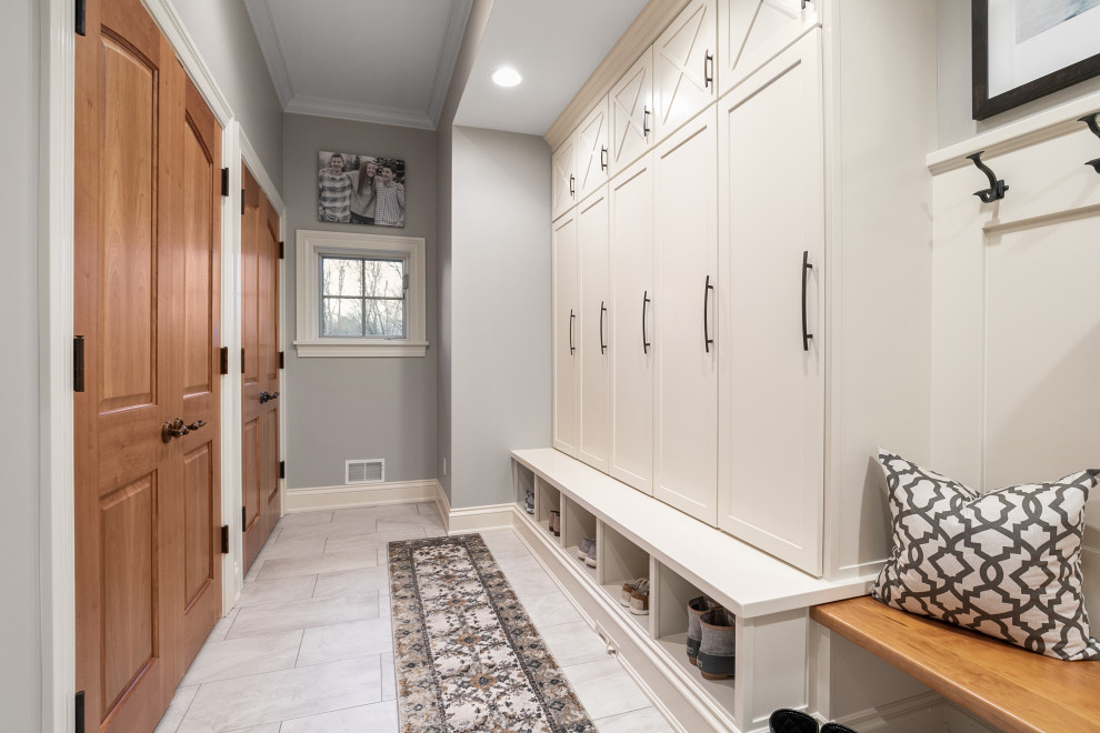 This is an example of a classic boot room in Grand Rapids with grey walls and grey floors.