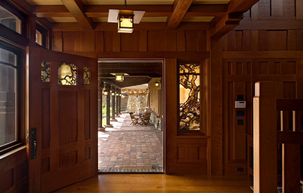 Foto de hall clásico con puerta simple, puerta de madera en tonos medios y suelo de madera en tonos medios