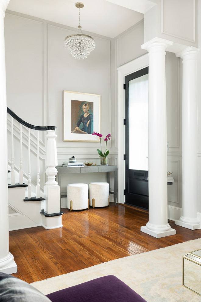 Klassisches Foyer mit grauer Wandfarbe, braunem Holzboden, Einzeltür, schwarzer Haustür, braunem Boden und Wandpaneelen in Louisville