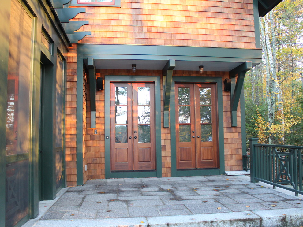 Cette photo montre une grande porte d'entrée craftsman avec sol en granite, une porte simple et une porte en bois brun.
