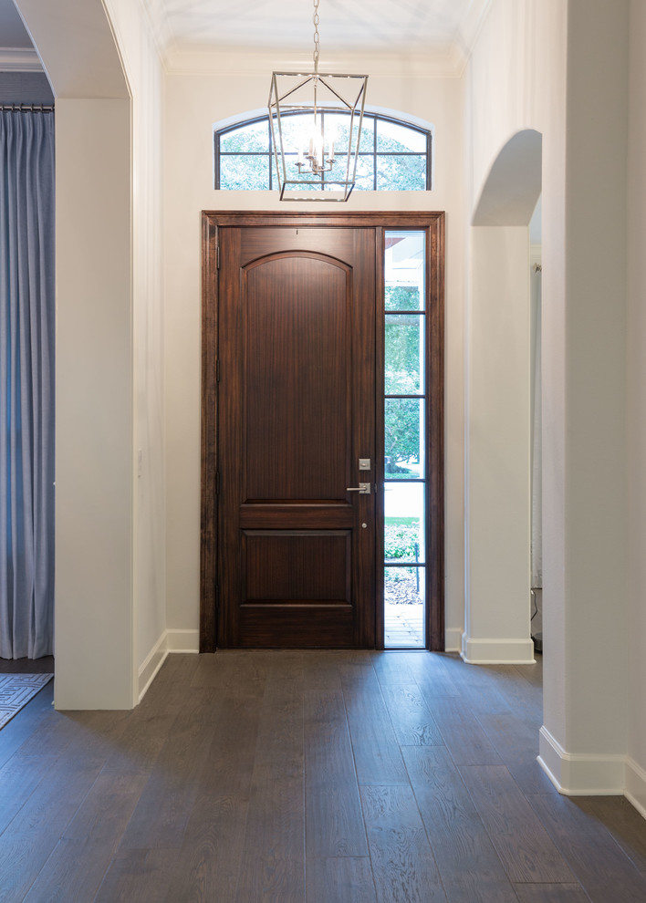 Esempio di una porta d'ingresso tradizionale di medie dimensioni con pareti beige, parquet scuro, una porta singola, una porta in legno scuro e pavimento marrone