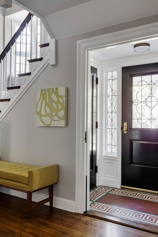 Modelo de vestíbulo clásico renovado de tamaño medio con paredes grises, suelo de madera en tonos medios, puerta pivotante, puerta negra y suelo marrón