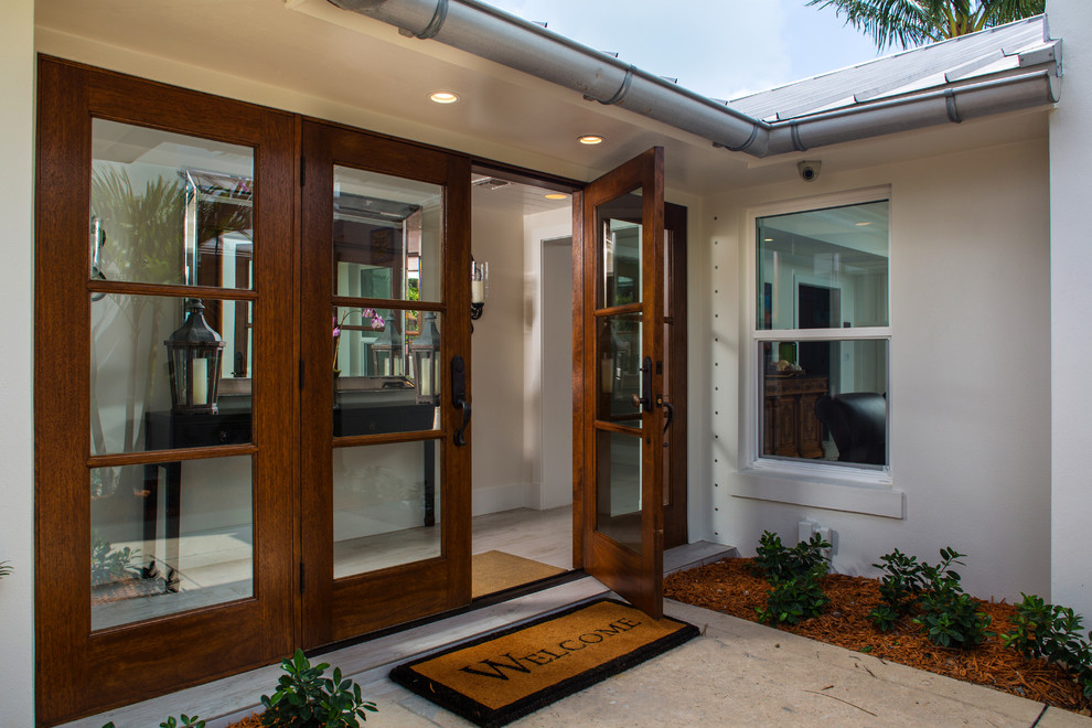 Inspiration for a medium sized traditional front door in Miami with white walls, light hardwood flooring, a double front door and a dark wood front door.