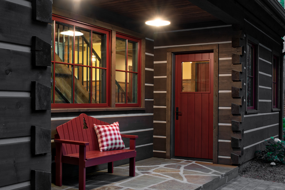 Foto di una porta d'ingresso stile rurale con pareti marroni, una porta singola, una porta rossa e pavimento grigio