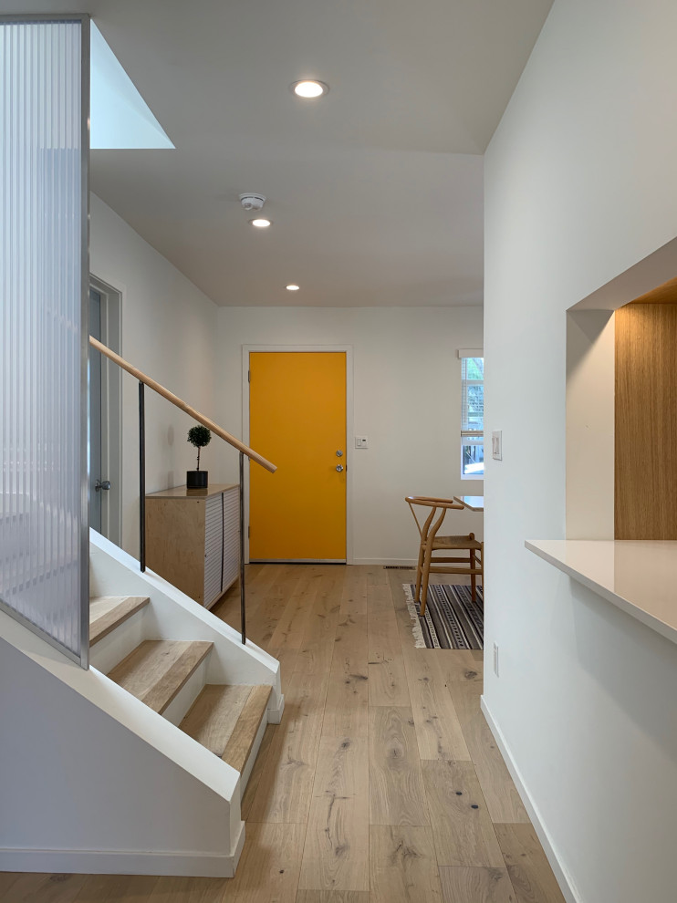 Diseño de hall tradicional renovado pequeño con paredes blancas, suelo de madera clara, puerta simple, puerta amarilla y suelo beige