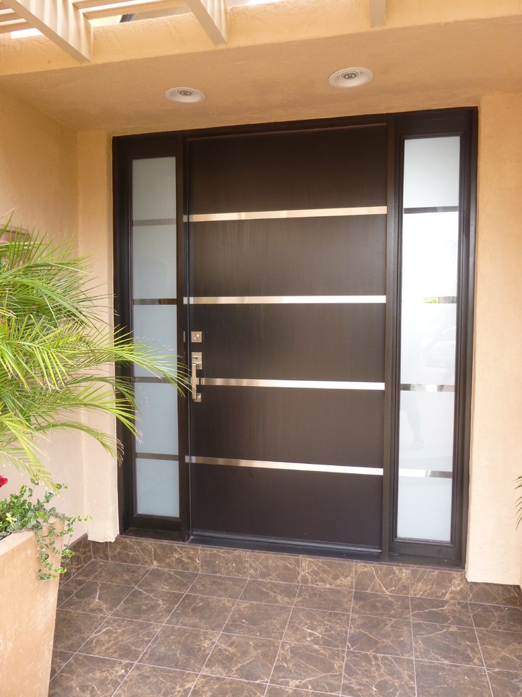 Idee per una grande porta d'ingresso design con pareti beige, una porta a pivot e una porta in legno scuro