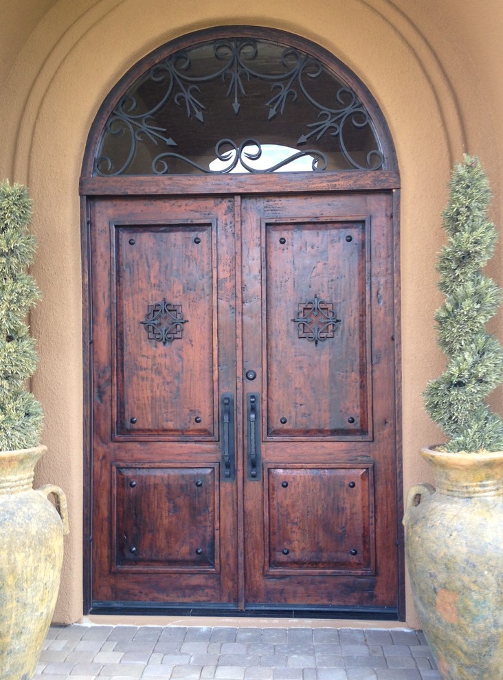 Immagine di una grande porta d'ingresso rustica con pareti beige, una porta a due ante e una porta in legno scuro