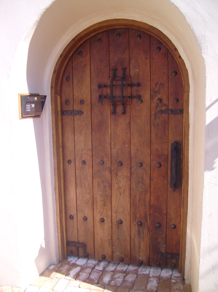 Esempio di una porta d'ingresso rustica di medie dimensioni con pareti beige, una porta singola e una porta in legno bruno