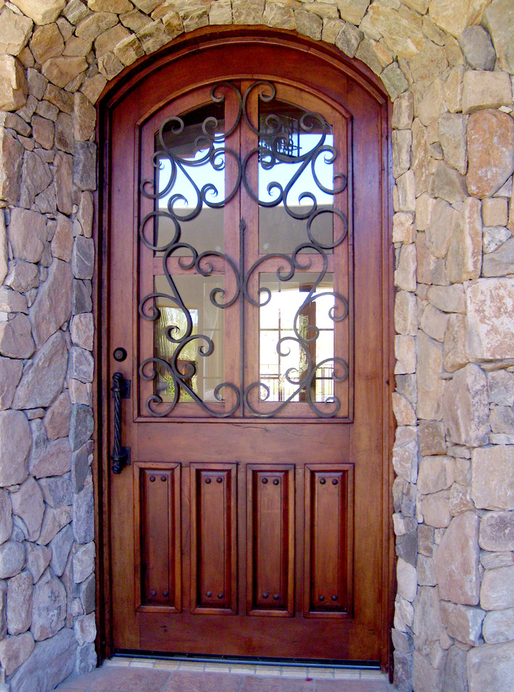 Foto på en mellanstor rustik ingång och ytterdörr, med flerfärgade väggar, en enkeldörr och mellanmörk trädörr