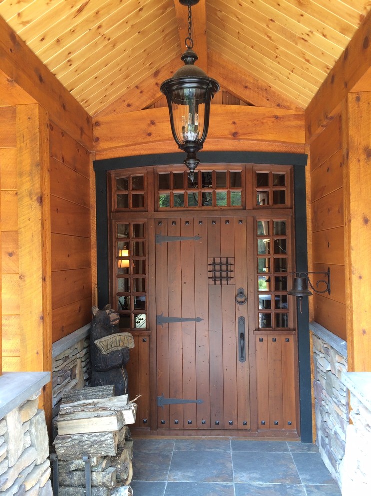 Idee per una porta d'ingresso rustica di medie dimensioni con pareti marroni, pavimento con piastrelle in ceramica, una porta singola, una porta in legno bruno e pavimento grigio