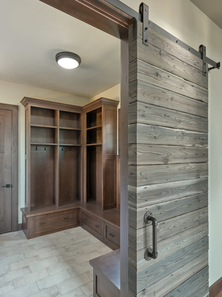 Inspiration pour une entrée craftsman de taille moyenne avec un vestiaire, un mur gris, parquet clair, une porte simple, une porte en bois foncé et un sol gris.