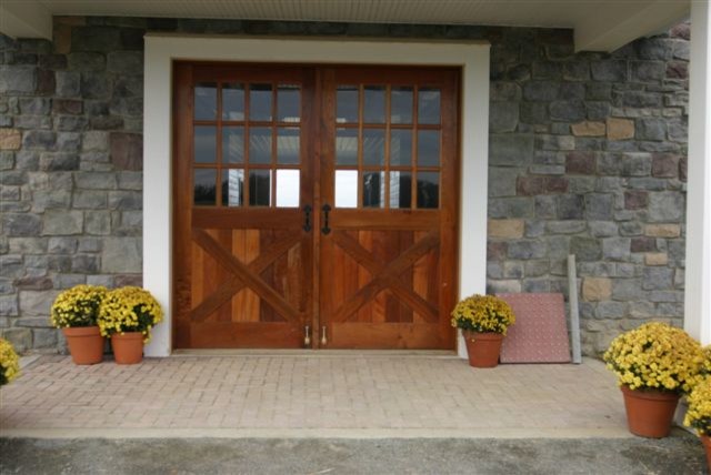 Ejemplo de puerta principal de estilo de casa de campo de tamaño medio con suelo de ladrillo, puerta doble y puerta de madera oscura