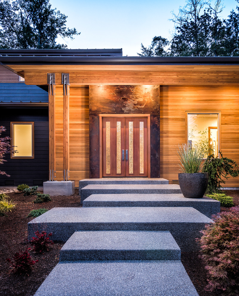 Design ideas for a contemporary front door in Seattle with concrete flooring, a double front door and a medium wood front door.