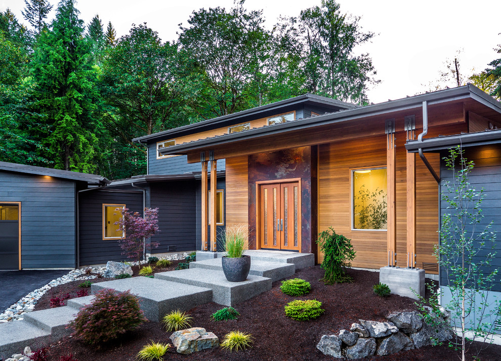 Moderne Haustür mit metallicfarbenen Wänden, Betonboden, Doppeltür und hellbrauner Holzhaustür in Seattle