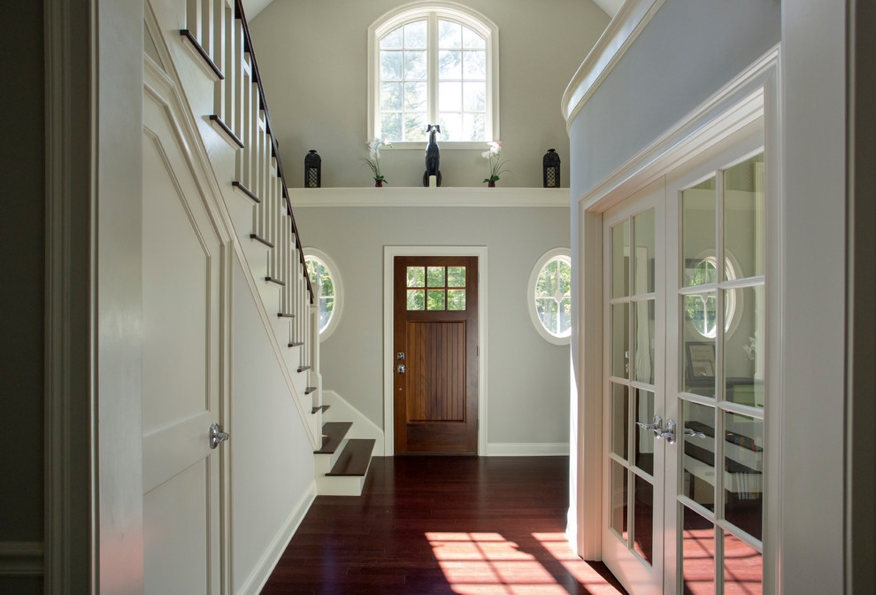 Example of a large transitional dark wood floor entryway design in Boston with white walls and a dark wood front door