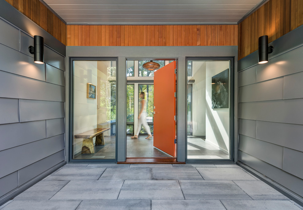 Стильный дизайн: входная дверь в современном стиле с одностворчатой входной дверью, оранжевой входной дверью и серым полом - последний тренд