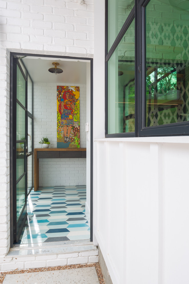 Modelo de entrada minimalista de tamaño medio con paredes blancas, puerta simple, puerta de vidrio y suelo azul
