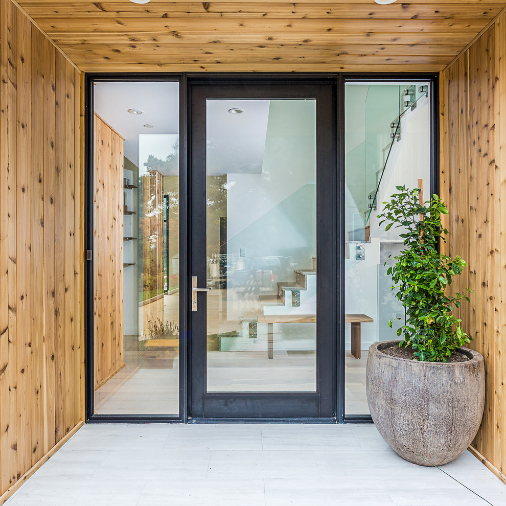 Aménagement d'une petite porte d'entrée contemporaine avec un mur marron, une porte simple et une porte en verre.