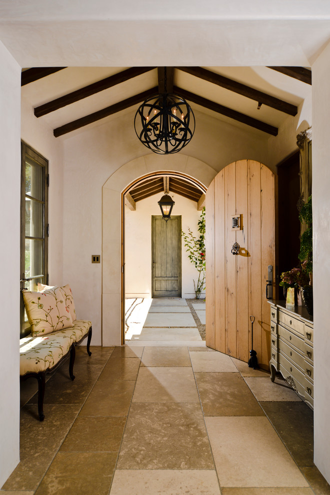 Imagen de entrada mediterránea con paredes beige, puerta simple y puerta de madera en tonos medios