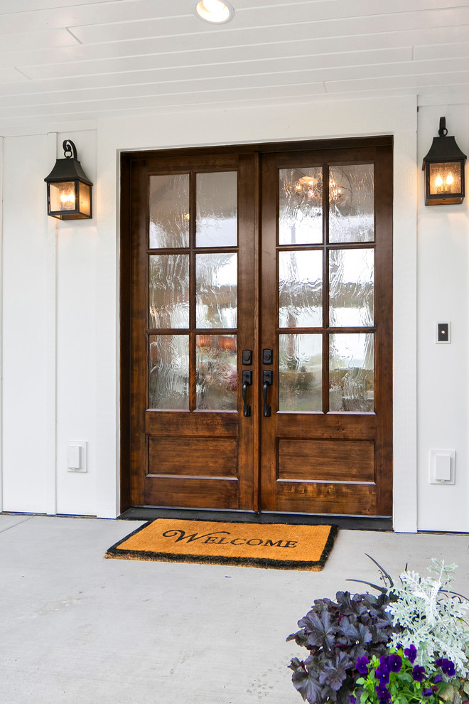 Example of a mid-sized beach style concrete floor entryway design in Seattle with white walls and a dark wood front door