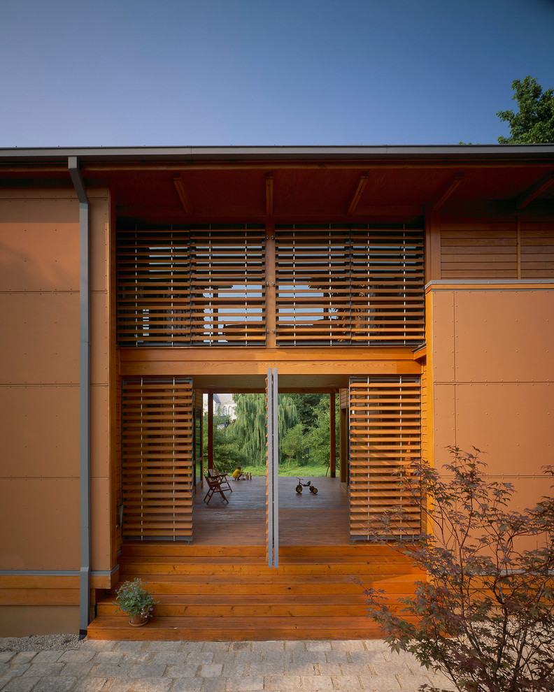 Kleine Moderne Haustür mit Drehtür, hellbrauner Holzhaustür, brauner Wandfarbe und hellem Holzboden in Richmond