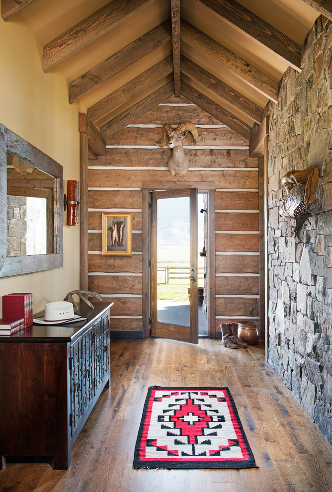 Foto de hall rural con paredes amarillas, puerta simple, puerta de vidrio y suelo de madera en tonos medios