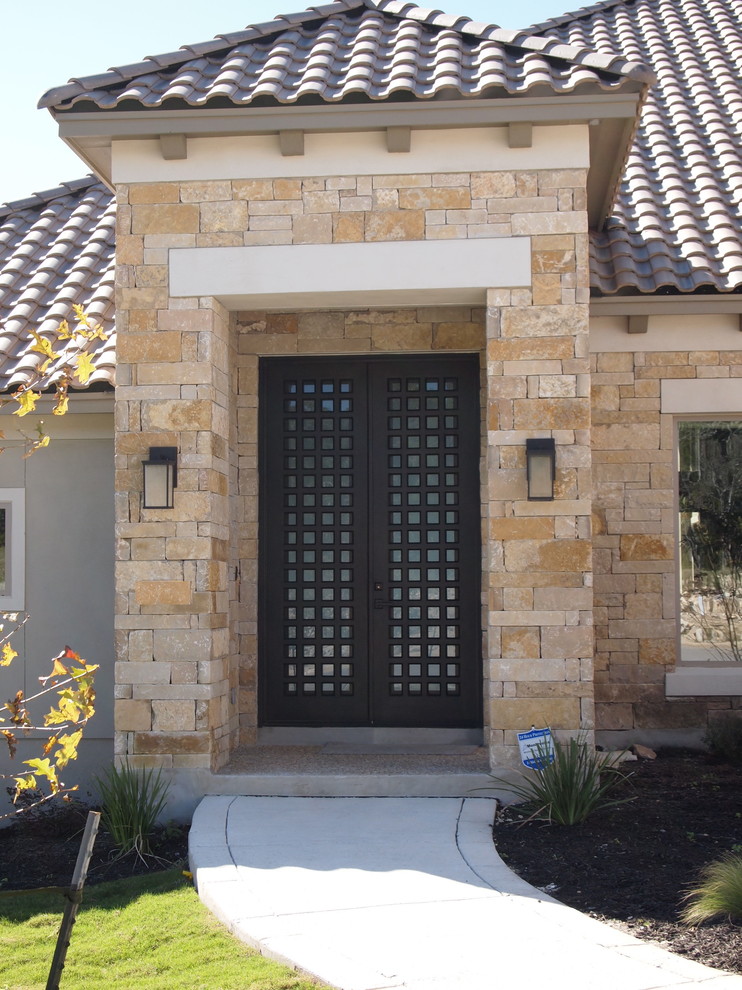 Immagine di una piccola porta d'ingresso chic con pareti marroni, pavimento in cemento, una porta a due ante e una porta in metallo