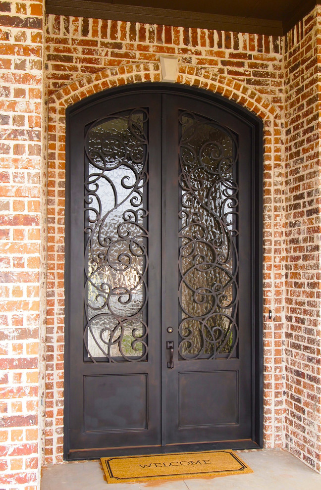 Inspiration for a small traditional front door in Austin with brown walls, concrete flooring, a double front door and a metal front door.