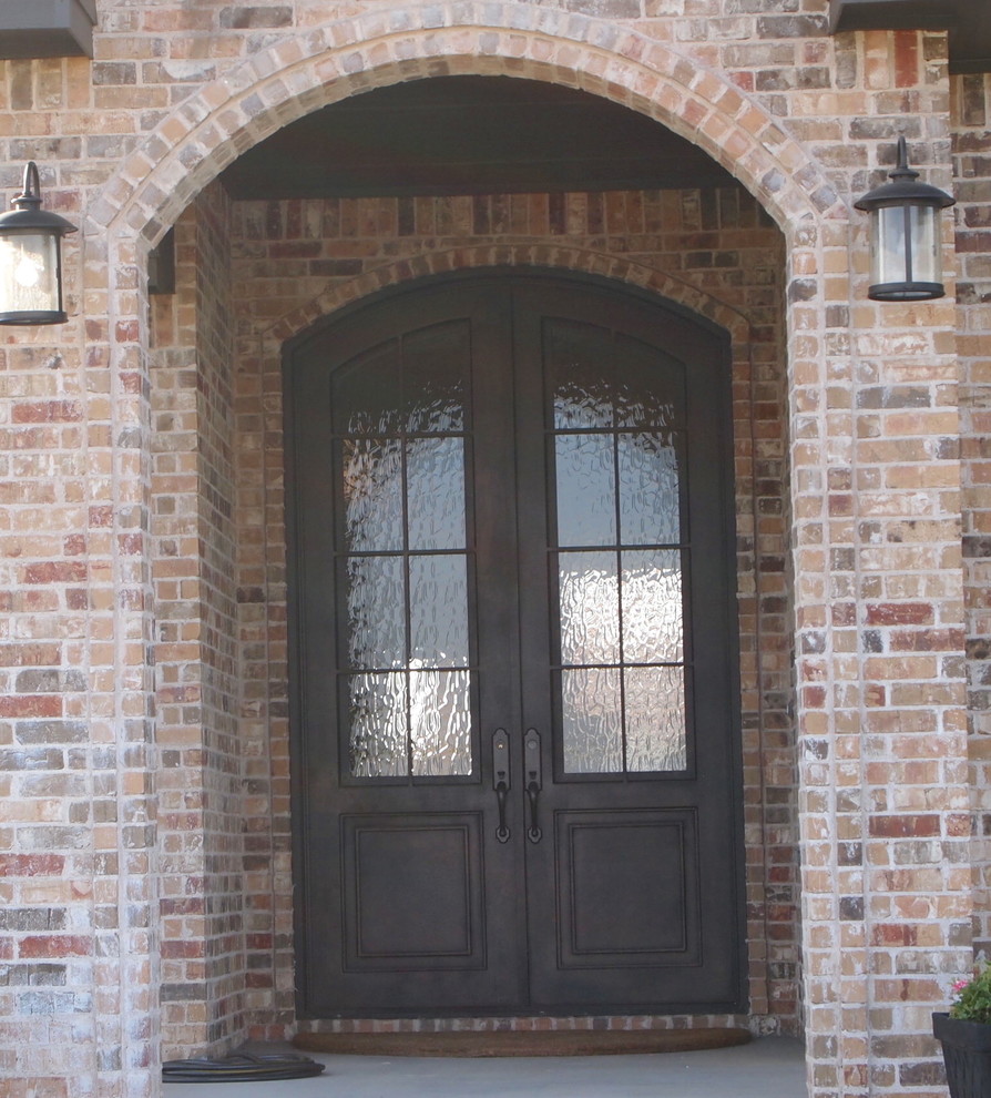 Diseño de puerta principal clásica pequeña con paredes marrones, suelo de cemento, puerta doble y puerta metalizada