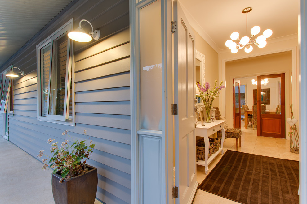 Foto de hall de estilo de casa de campo de tamaño medio con paredes beige, suelo de baldosas de porcelana, puerta simple y puerta blanca