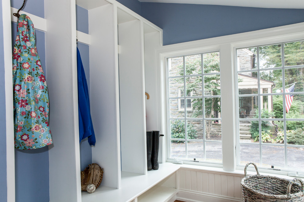 Exemple d'une entrée tendance de taille moyenne avec un couloir, un mur bleu, un sol en bois brun, une porte simple et une porte en bois brun.