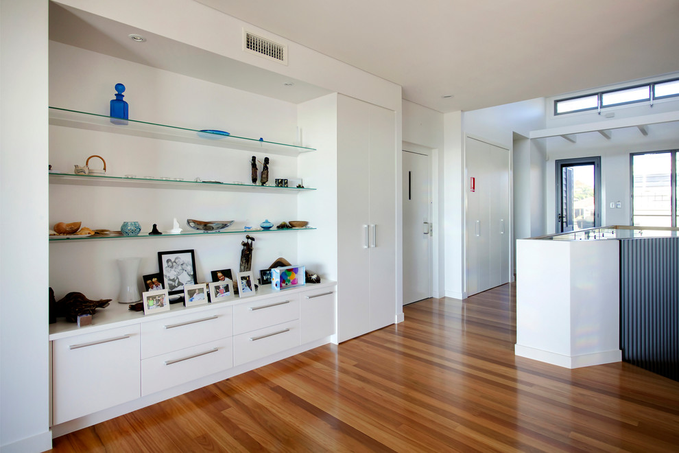 Großes Modernes Foyer mit weißer Wandfarbe, Drehtür, Haustür aus Glas, hellem Holzboden und braunem Boden in Brisbane