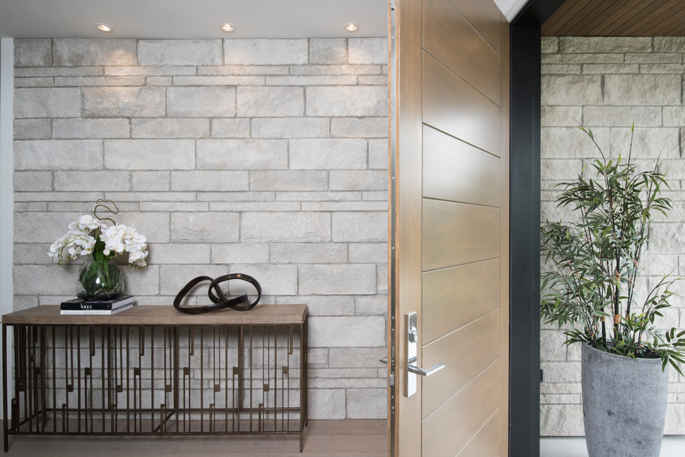Foto de distribuidor minimalista de tamaño medio con paredes grises, suelo de madera en tonos medios, puerta simple, puerta de madera en tonos medios y suelo marrón