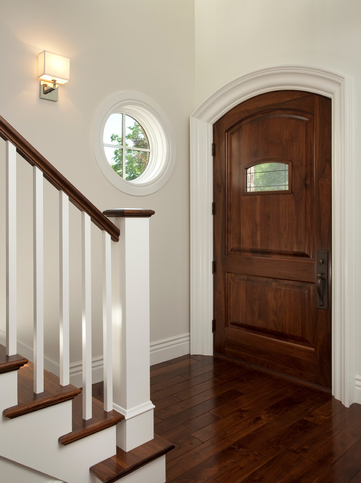 Inspiration pour un grand hall d'entrée traditionnel avec un mur gris, parquet foncé, une porte simple et une porte en bois foncé.