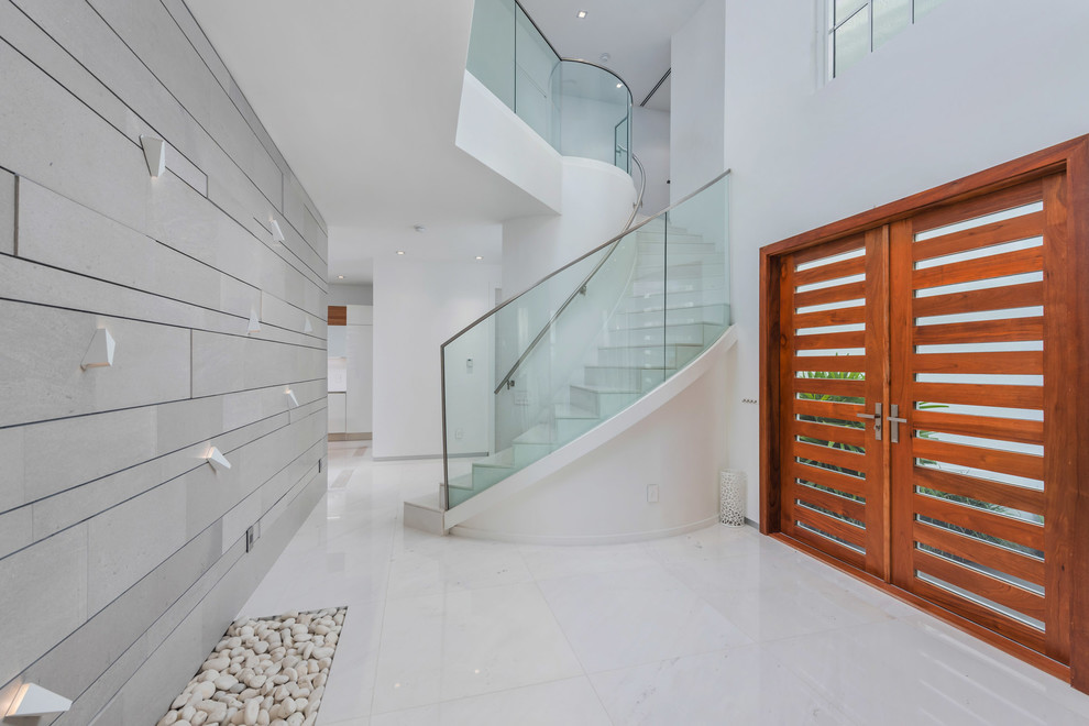 Immagine di un ingresso o corridoio minimal con pareti bianche, una porta a due ante, una porta in legno bruno e pavimento bianco