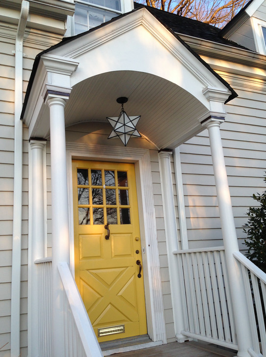Cette image montre une porte d'entrée traditionnelle de taille moyenne avec un mur beige, une porte simple et une porte jaune.
