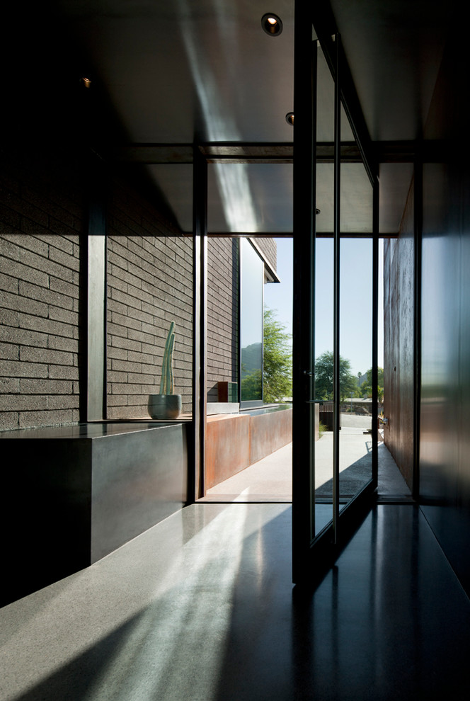 Exempel på en stor modern ingång och ytterdörr, med grå väggar, terrazzogolv, en pivotdörr och metalldörr