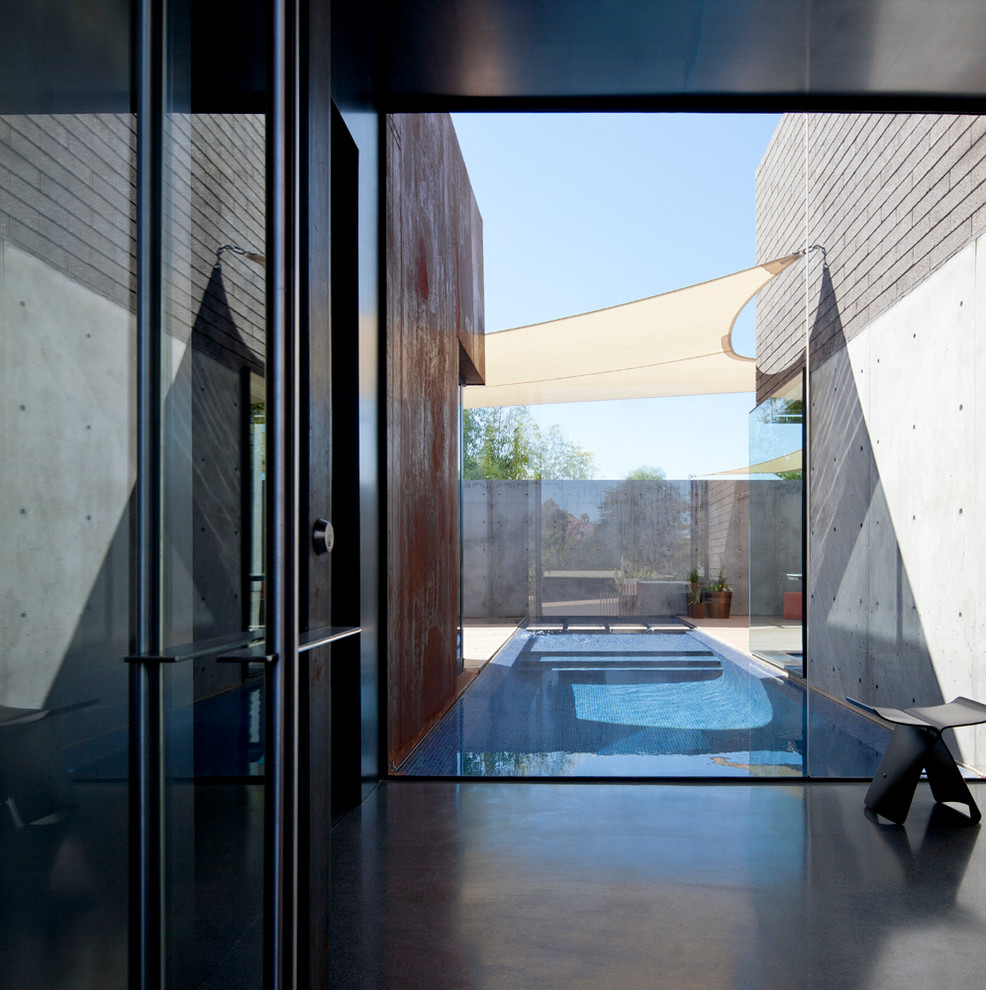 Idées déco pour une entrée moderne avec un mur gris, un sol en terrazzo, une porte pivot et une porte métallisée.