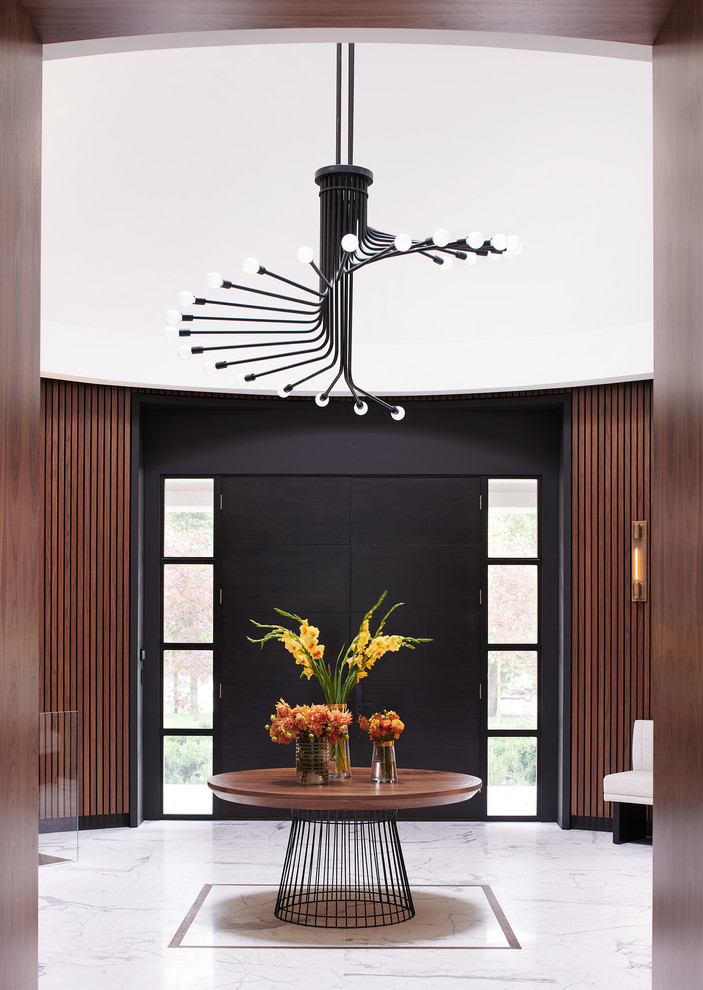 На фото: фойе в стиле модернизм с коричневыми стенами, мраморным полом, двустворчатой входной дверью, черной входной дверью и белым полом с