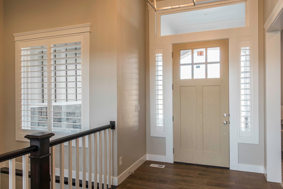 Modelo de puerta principal de estilo americano de tamaño medio con paredes beige, suelo de madera en tonos medios, puerta simple, puerta marrón y suelo marrón
