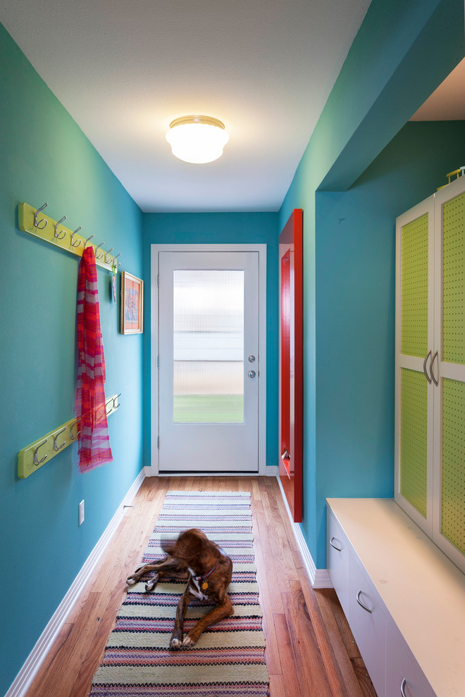オースティンにある高級な小さなトランジショナルスタイルのおしゃれな玄関ホール (青い壁、白いドア、無垢フローリング) の写真