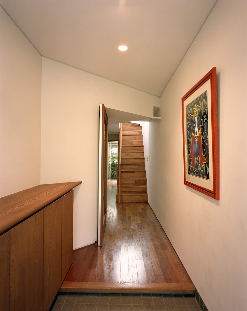 Foto di un corridoio moderno di medie dimensioni con pareti grigie, pavimento in gres porcellanato, una porta singola, una porta in metallo e pavimento grigio