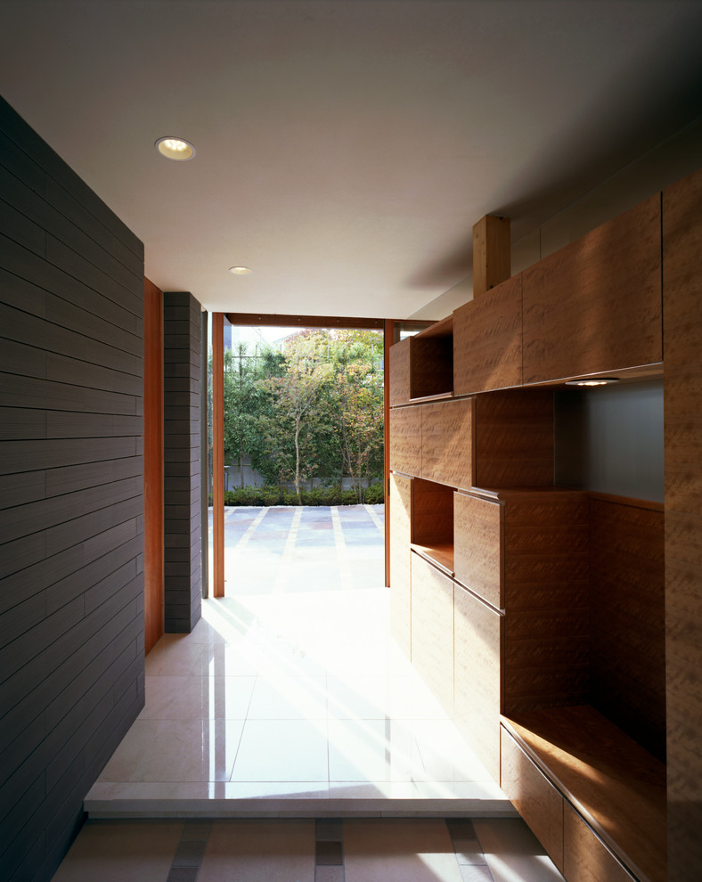 Inspiration pour une grande entrée minimaliste avec un couloir, un mur gris, un sol en marbre, une porte simple, une porte en bois brun et un sol beige.