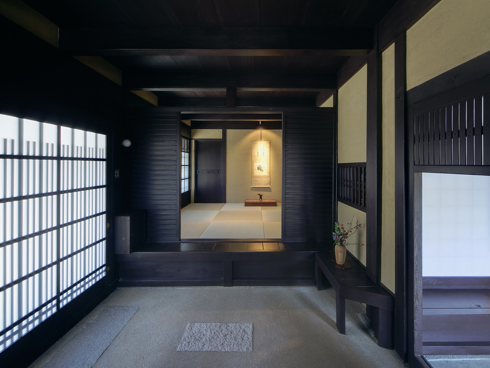 Foto di un ingresso con vestibolo design con pareti beige e una porta nera