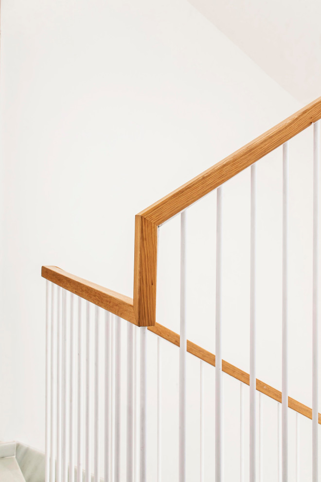 Стильный дизайн: п-образная лестница среднего размера в стиле неоклассика (современная классика) с мраморными ступенями, подступенками из мрамора и деревянными перилами - последний тренд
