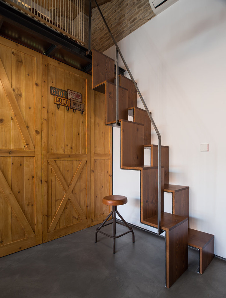 Imagen de escalera recta urbana de tamaño medio con escalones de madera, contrahuellas de madera y barandilla de metal