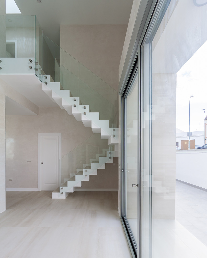 Großes Modernes Treppengeländer Glas in U-Form mit gefliesten Treppenstufen und gefliesten Setzstufen in Sevilla