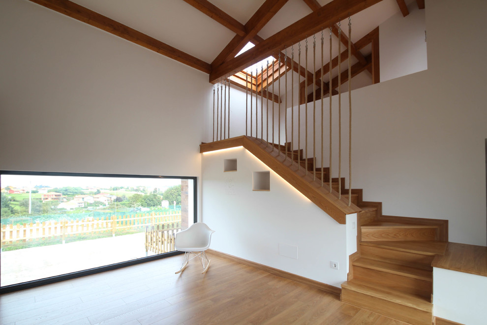 Foto de escalera en L nórdica de tamaño medio con escalones de madera y contrahuellas de madera