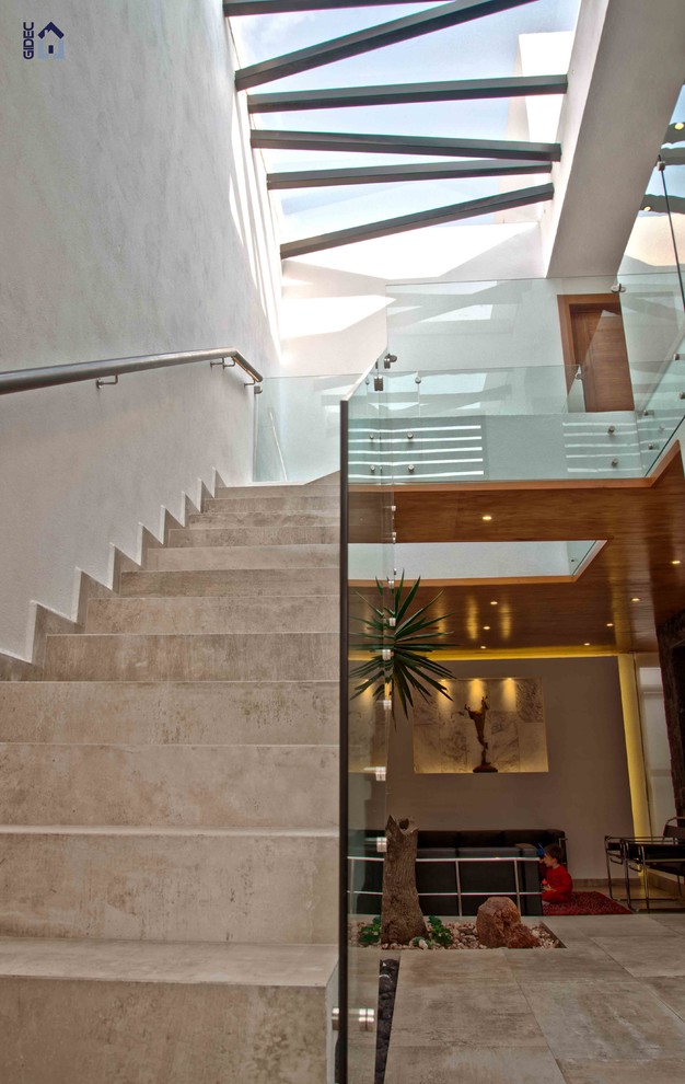 Photo of a modern concrete straight staircase in Mexico City with tiled risers.