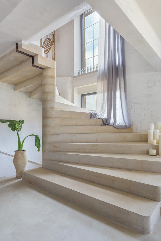 Стильный дизайн: большая изогнутая бетонная лестница в стиле кантри с бетонными ступенями - последний тренд
